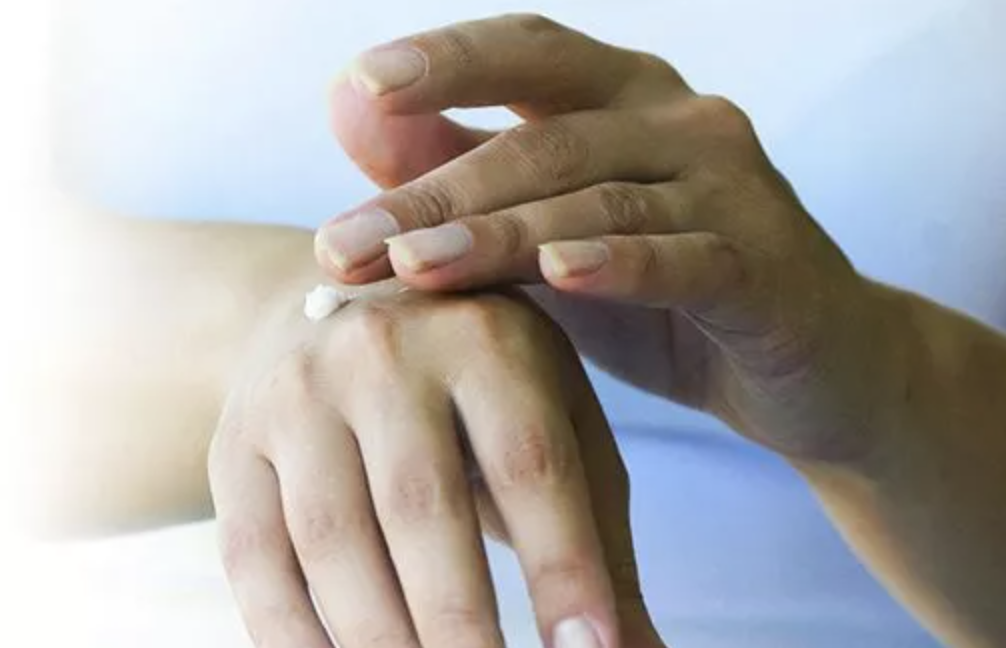 Photo of woman applying lotion to her hand
